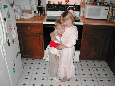 A big hug for brother & sister while playing dress-up on May 3, 2002